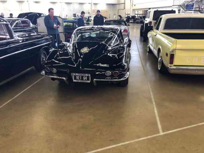Classic cars on display including vintage Corvette
